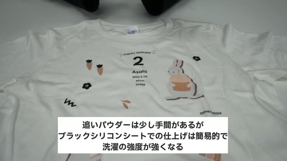 パウダープリントフィルムでプリントした白いTシャツ。誕生日のイラストと名前が入っている