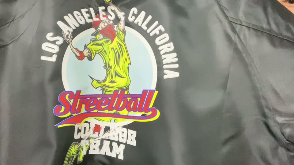 黒っぽいコーチジャケットに、LOS ANGELES CALIFORNIA・Streetball・COLLEGE TEAMの文字とキャラクターを白を含むフルカラーでプリントした仕上がり