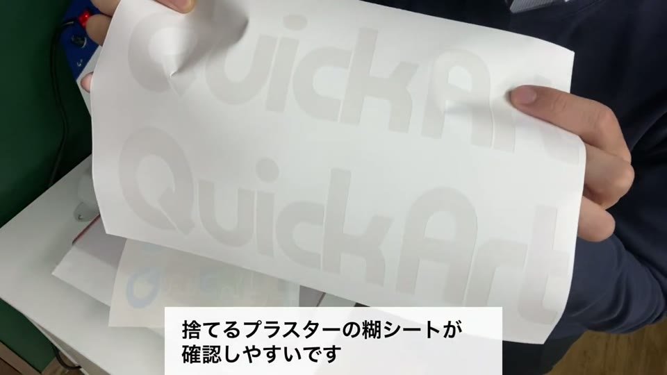 剥がしたあとのプラスターシートを持ち上げて、ロゴの形に糊が抜けている様子と、捨てるプラスターの糊シートが確認しやすいというテロップ