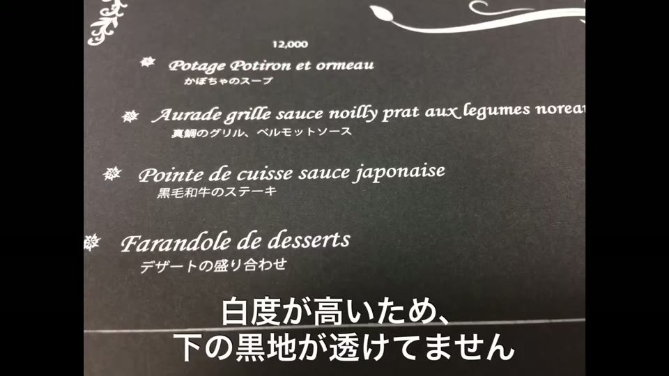 黒い紙に白で印刷したメニューの拡大。フランス語と日本語の料理名がくっきり読める