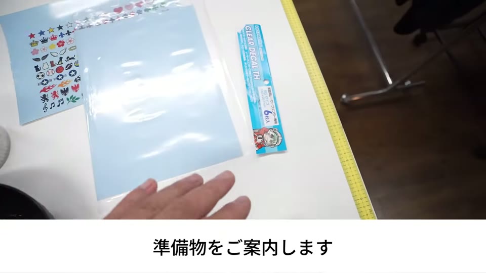 作業台の上に置いた印刷済みのデカールシート、未使用のクリアデカールTHとそのパッケージ