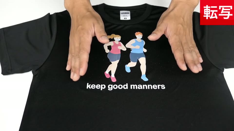 裏紙を剥がし終えた黒のドライTシャツ。走る男女のイラストとkeep good mannersの文字