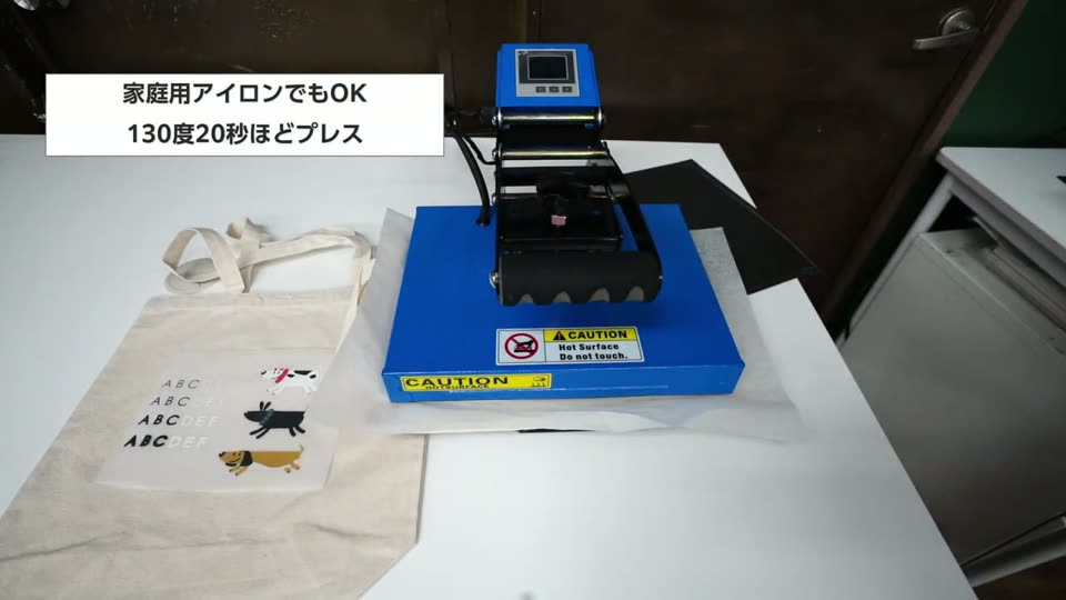 薄手のファイルバッグにシリコン紙をのせてミニプレス機でプレスしている様子。テロップは家庭用アイロンでもOK、130度20秒ほどプレス