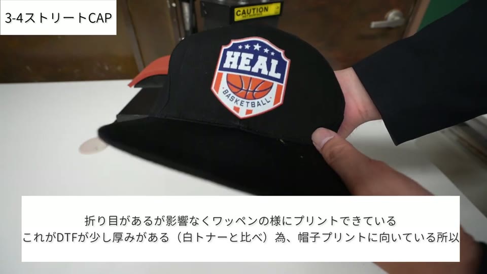 黒いストリートキャップの前面にHEAL BASKETBALLのエンブレムがフルカラーでプリントされている