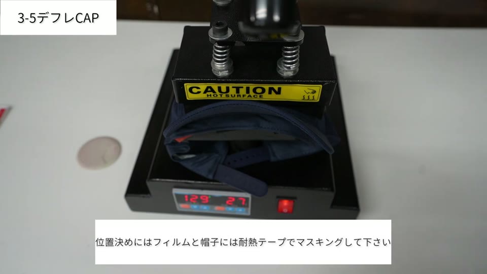 紺色のキャップをセットした帽子プレス機。テロップは位置決めにはフィルムと帽子には耐熱テープでマスキングして下さい
