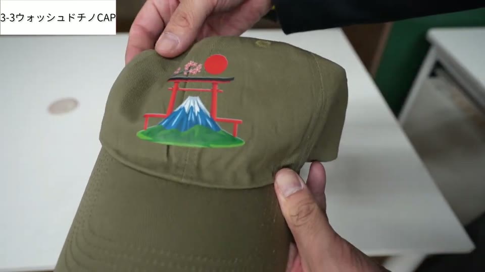 カーキのウォッシュドチノキャップに富士山と鳥居のイラストがプリントされている