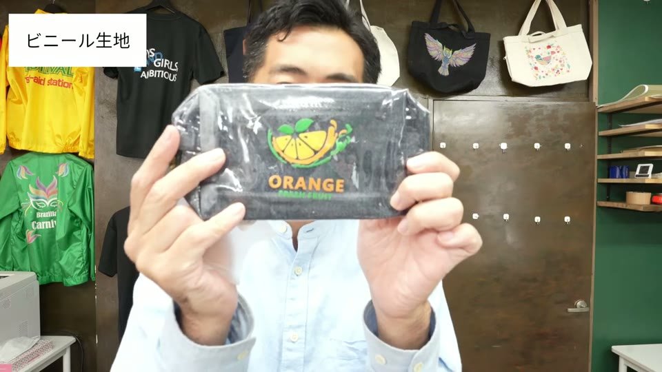 透明なビニールのポーチに、オレンジのイラストと「ORANGE」の文字がプリントされている