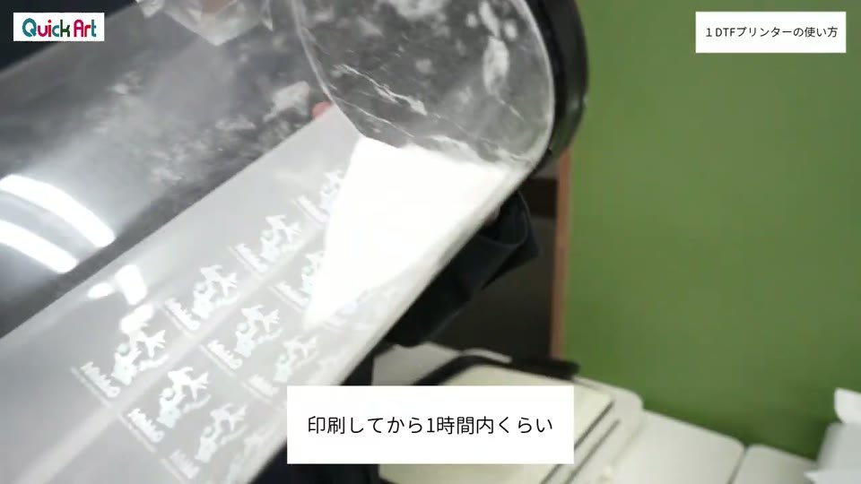 印刷したフィルムの上に、容器から白いパウダーをかけている様子