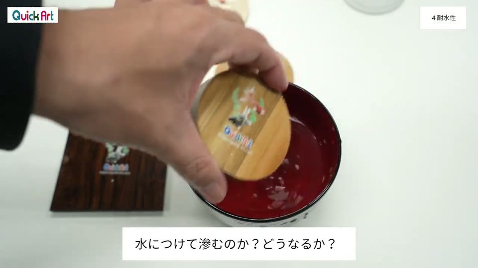 プリントしたカツラの丸い木材を、水の入った赤いお椀につけている様子