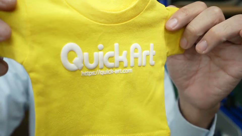 黄色いTシャツに白く膨らむQuickArtのロゴをプリントした例