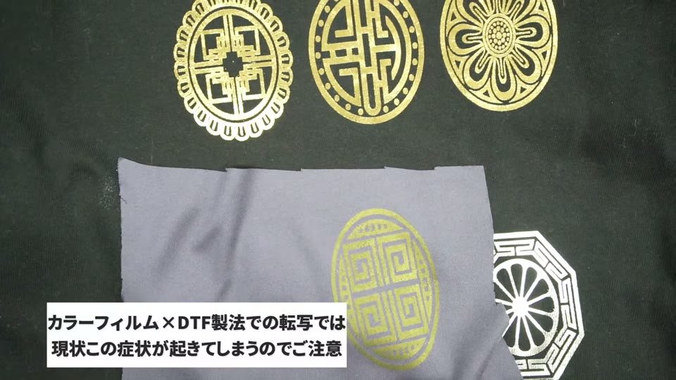 黒いTシャツ上に並べた、トナーで作った金の家紋柄と、グレーの生地にDTFのカラーフィルムで作った金の柄の比較