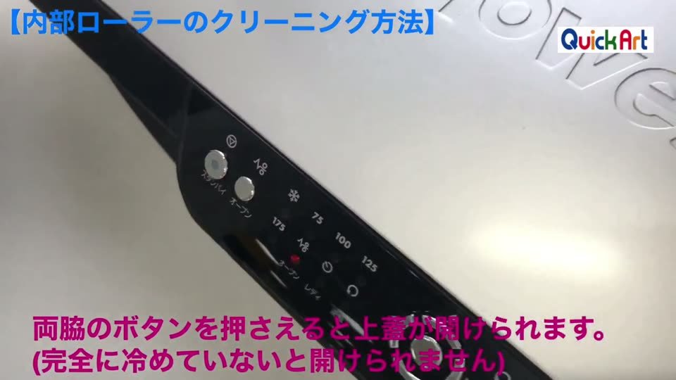 抜けるラミネーターの操作パネルに指を添えている。テロップは両脇のボタンを押さえると上蓋が開けられます。完全に冷めていないと開けられません