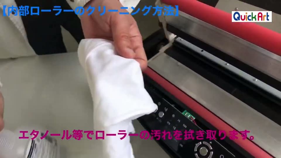 上蓋を開けた抜けるラミネーターの赤いローラーを白い布で拭いている。テロップはエタノール等でローラーの汚れを拭き取ります