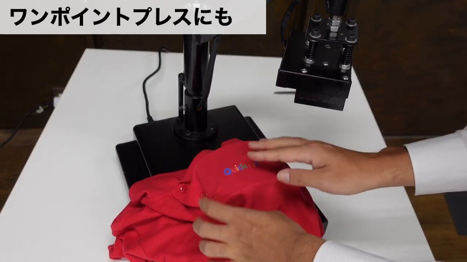 赤いポロシャツを帽子プレス機の下ゴテにかぶせ、胸元に小さなロゴをプレスする様子