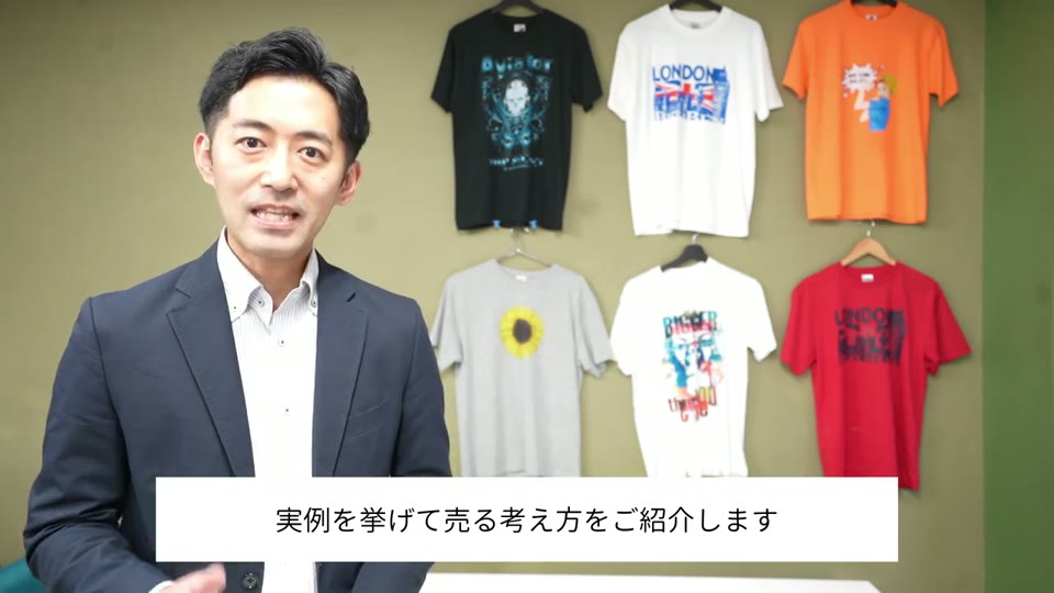 プリントTシャツが並ぶ前で売り方を解説する
