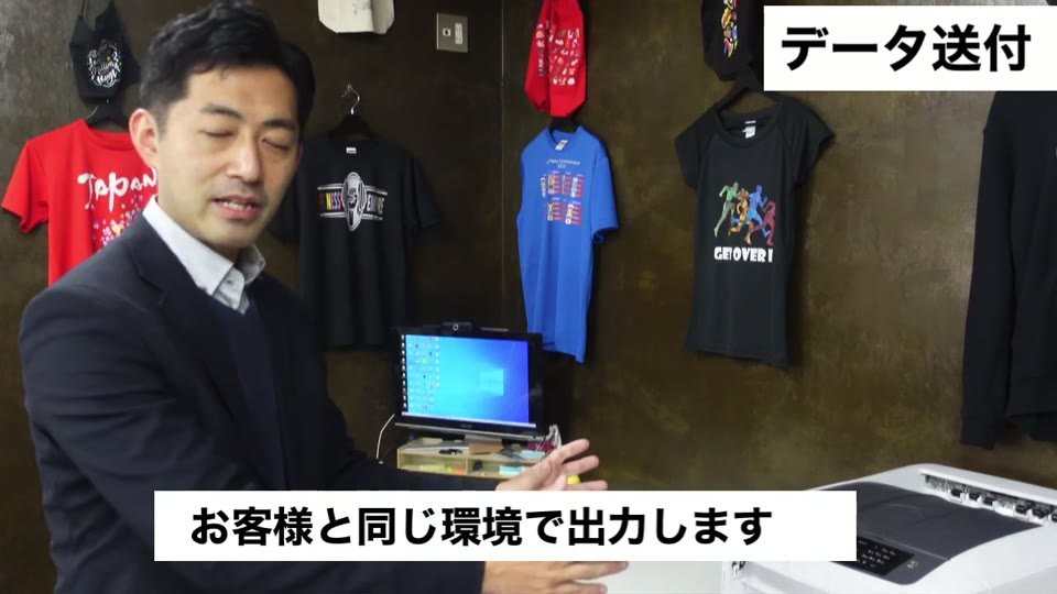 パソコンとプリンターの前で「お客様と同じ環境で出力します」とテロップが出ている場面