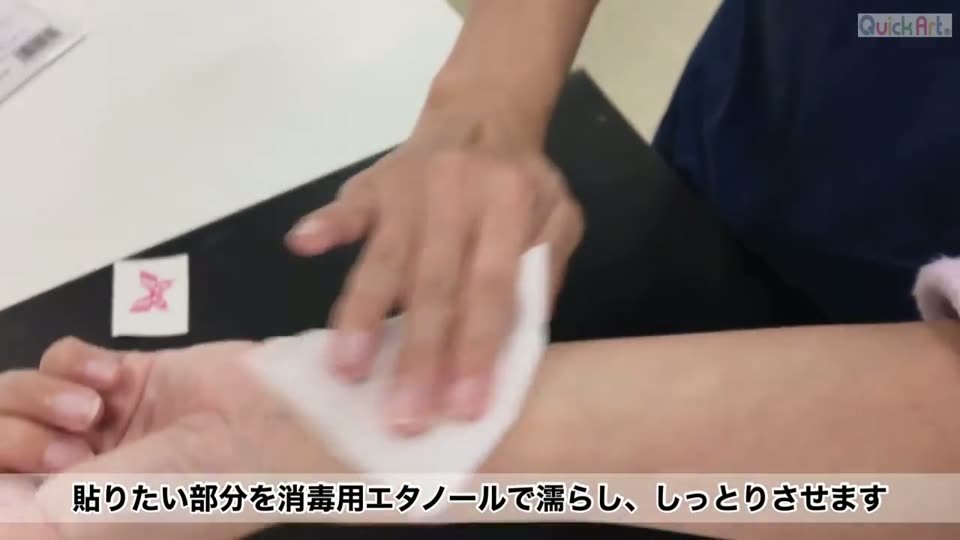 腕の貼りたい部分を、消毒用エタノールを含ませたティッシュで湿らせているところ