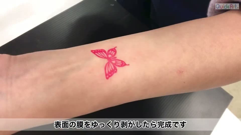 腕に貼った赤いちょうちょのタトゥーシール。デザインの周りに枠や余白のテカリがない