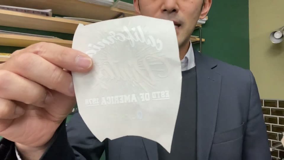 デザインの形に合わせて角を落としながら切った転写シートを手に持っている様子