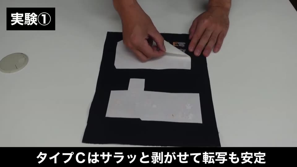 黒の帆布にタイプCで転写したマークの裏紙を剥がしている様子。テロップはタイプCはサラッと剥がせて転写も安定