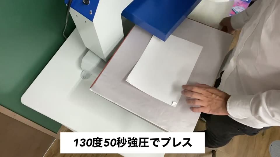 プレス機の下ゴテに重ねたシートをのせている様子。テロップは130度50秒強圧でプレス