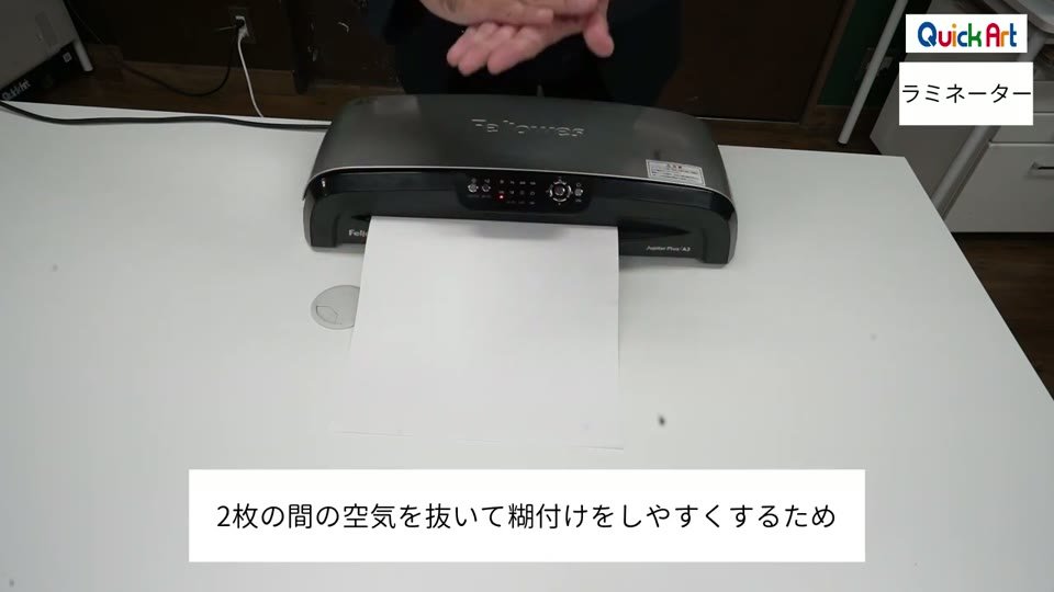 A3の2枚のシートを重ねてラミネーターに通している様子と、2枚の間の空気を抜いて糊付けをしやすくするためという字幕