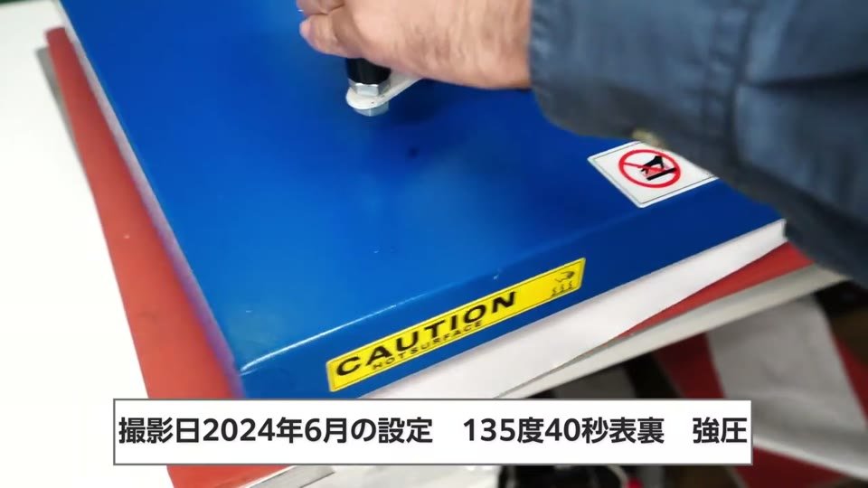 青いスウィング式プレス機で、135度40秒表裏・強圧と字幕が出ているプレスの様子