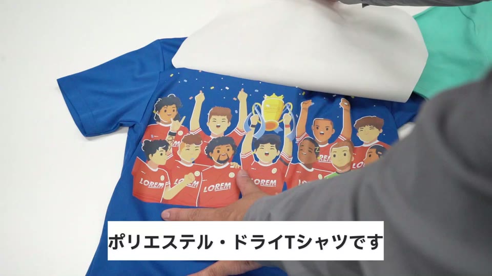 青いポリエステルのドライTシャツにタイプWLでサッカーチームのイラストを転写し、裏紙を剥がしているところ