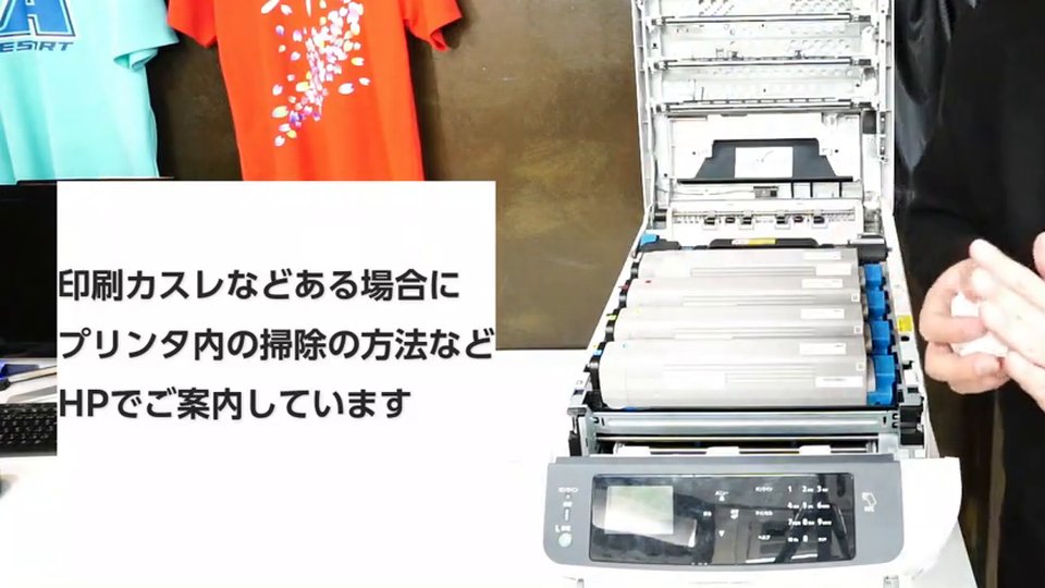 前面のカバーを開けたレーザープリンターの中にトナーとドラムが並んでいる様子。テロップは「印刷カスレなどある場合にプリンタ内の掃除の方法などHPでご案内しています」