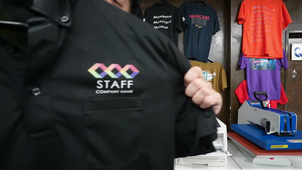 黒いポリエステルのポロシャツの胸にプリントしたSTAFFのロゴ