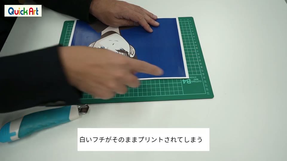 カッティングマットの上でWHS-CLに印刷したイラストの白い余白をカットしているところ。「白いフチがそのままプリントされてしまう」のテロップ