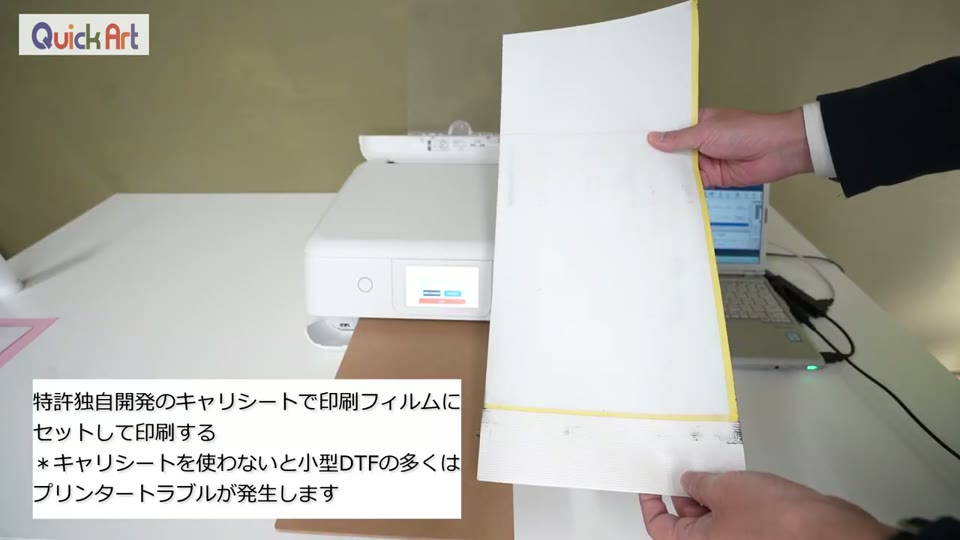 黄色い枠のキャリーシートに印刷フィルムをセットし、WIP754の給紙口に差し込もうとしている