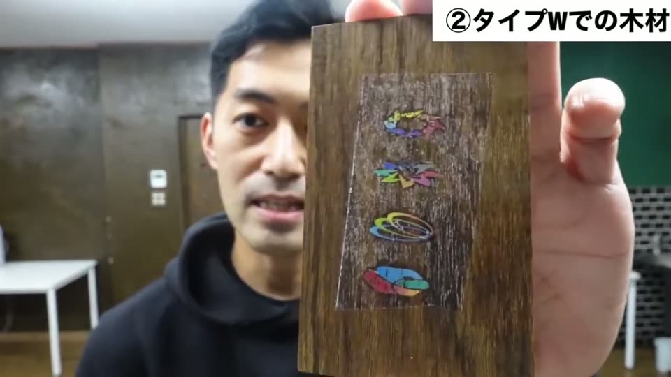 Type-Wで濃い色の木片に転写した小さな柄。柄のまわりに四角い膜がうっすら見える