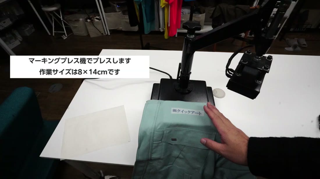 作業服の胸ポケット上にマーキングプレス機で社名をプレスする様子